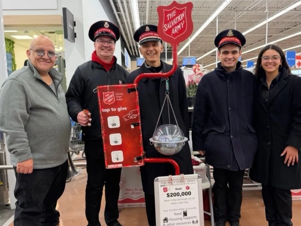 Five Salvation Army kettle volunteers stand at a kettle at a Walmart in Milton